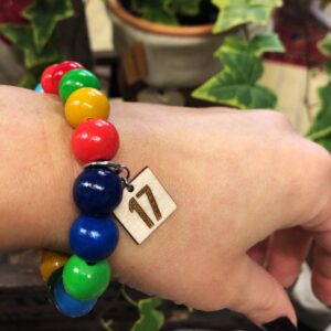 Armband med färgglada kulor och en tag som det står 17 på.
