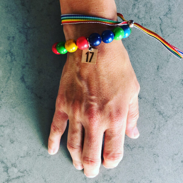 En hand sedd uppifrån med två färgglada armband.